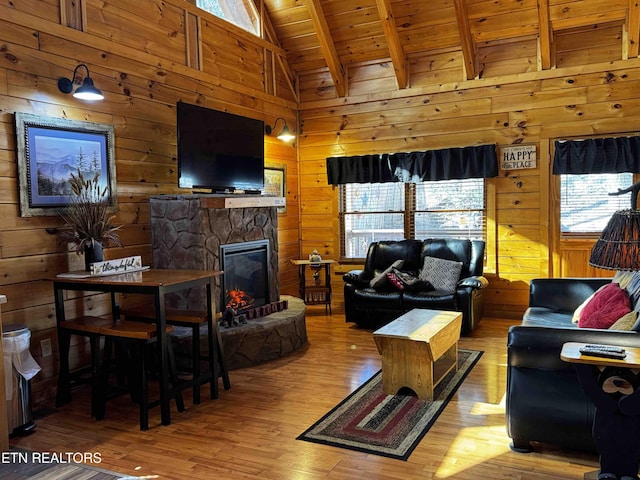 living area with plenty of natural light, wooden ceiling, wood walls, and beamed ceiling