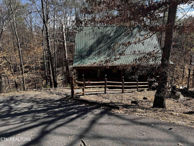 view of front facade with aphalt driveway and fence