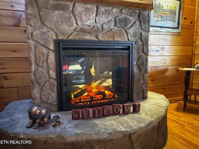 details featuring wood walls, a fireplace, and wood finished floors