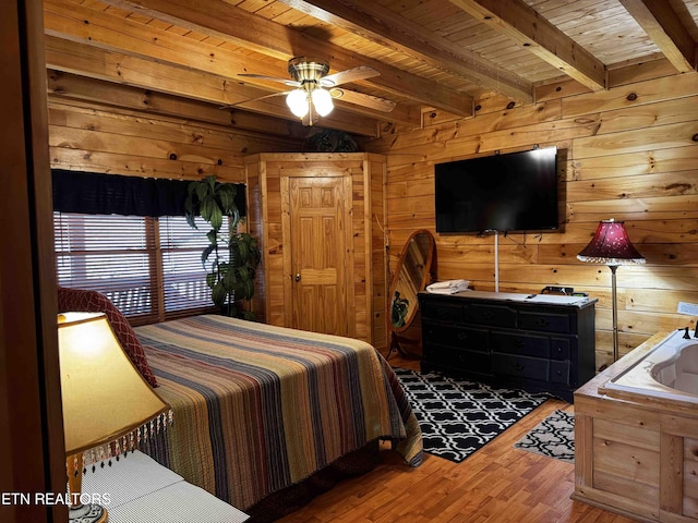 bedroom with wood walls, wood ceiling, wood finished floors, and beamed ceiling