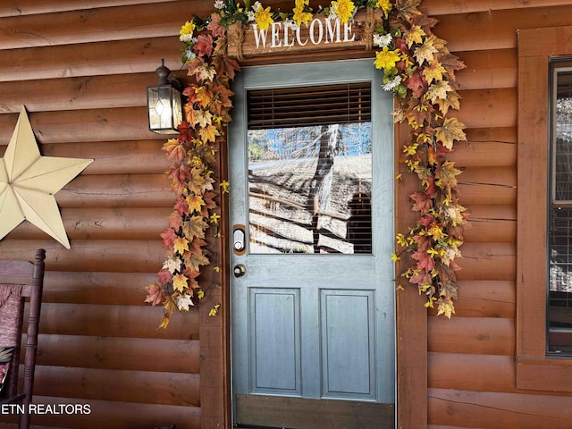 property entrance featuring faux log siding