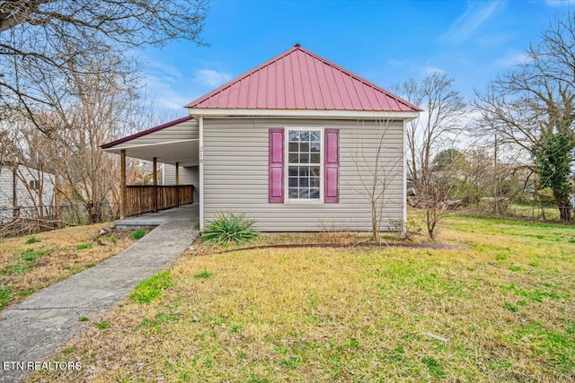 exterior space featuring metal roof and a yard