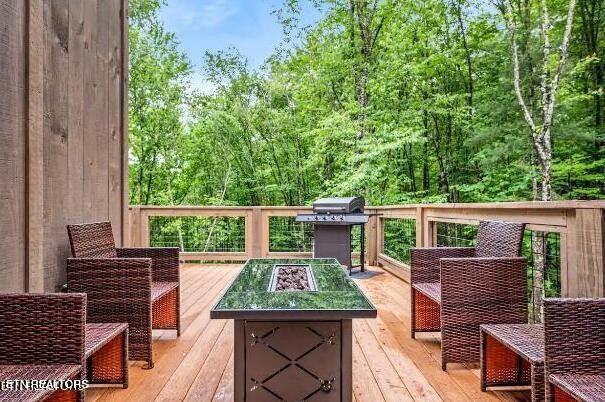 wooden terrace with an outdoor living space with a fire pit