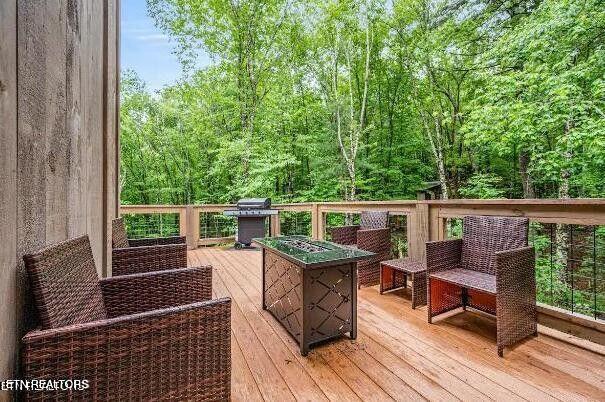 wooden deck featuring a grill and a fire pit