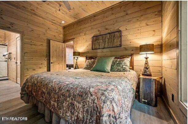 bedroom with wooden ceiling, wooden walls, and wood finished floors