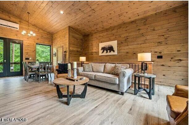 living area featuring a wall unit AC, wooden ceiling, wooden walls, and wood finished floors