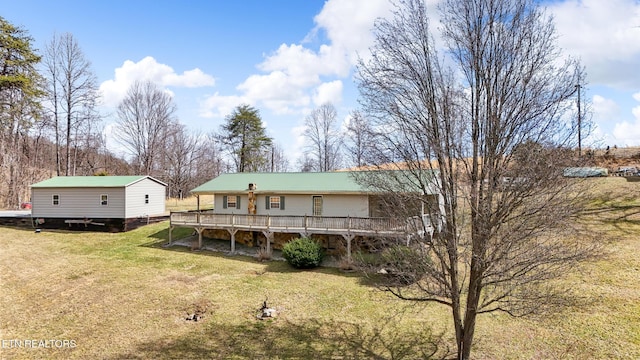 rear view of house featuring a lawn and a deck