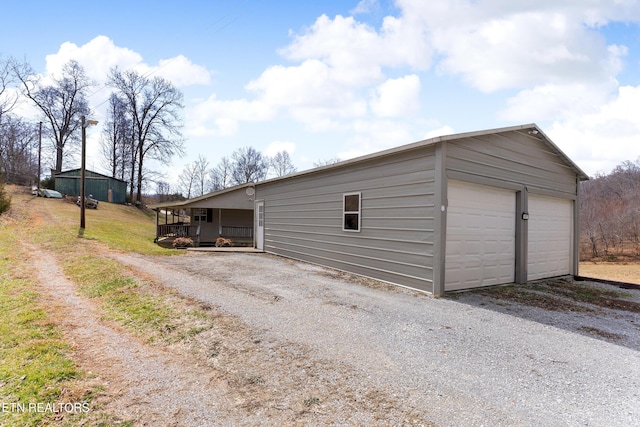 exterior space with a detached garage and an outbuilding