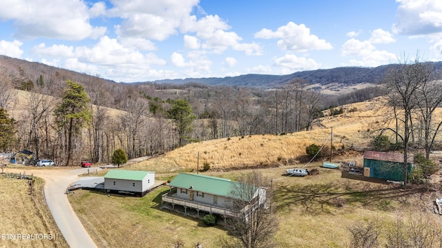 birds eye view of property featuring a rural view, a mountain view, and a view of trees