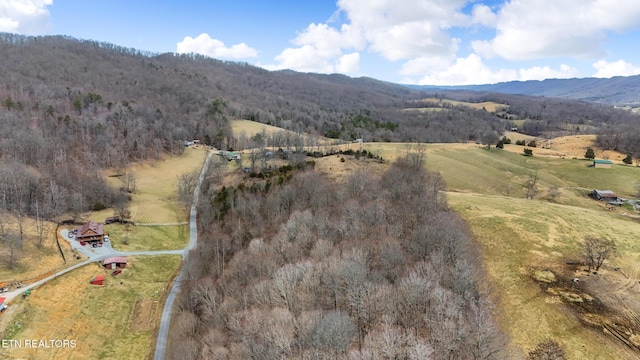aerial view featuring a wooded view and a mountain view