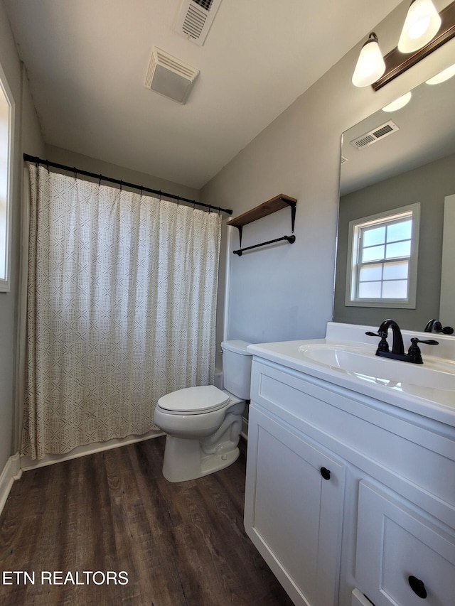 full bathroom featuring toilet, visible vents, wood finished floors, and vanity