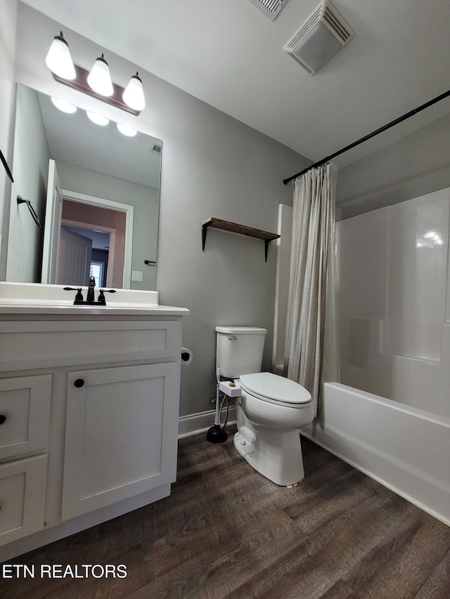 bathroom with shower / tub combo with curtain, visible vents, toilet, vanity, and wood finished floors