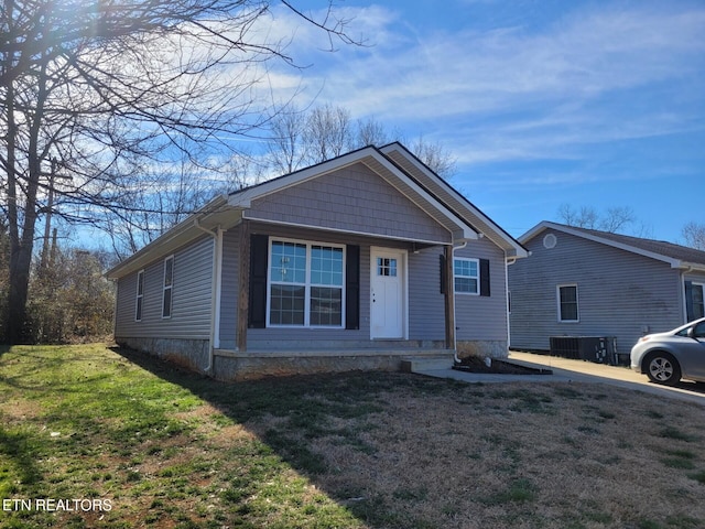 view of front of home with a front lawn and central air condition unit