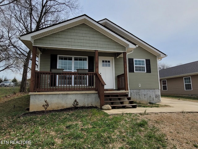 bungalow featuring a porch and a front lawn