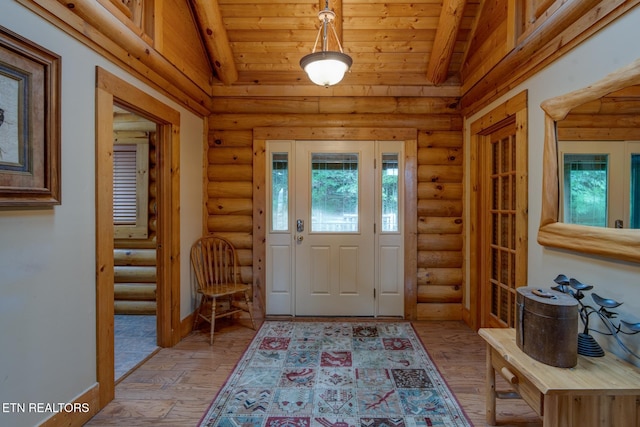 foyer featuring lofted ceiling, light wood finished floors, and log walls