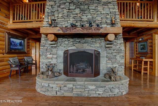 interior details featuring log walls, wood finished floors, and a stone fireplace