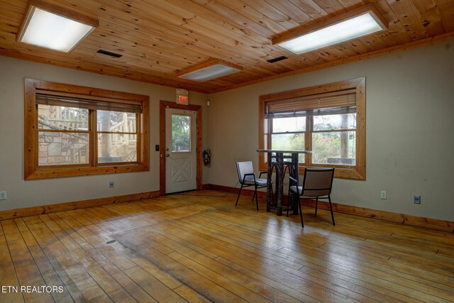 interior space with wood-type flooring, wooden ceiling, visible vents, and baseboards