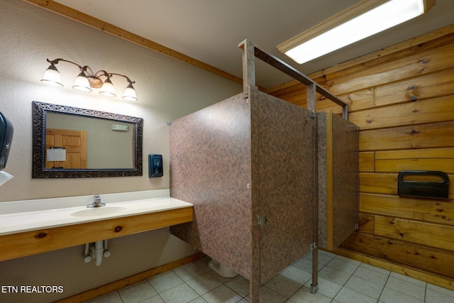 full bath featuring tile patterned flooring, a walk in shower, and a sink