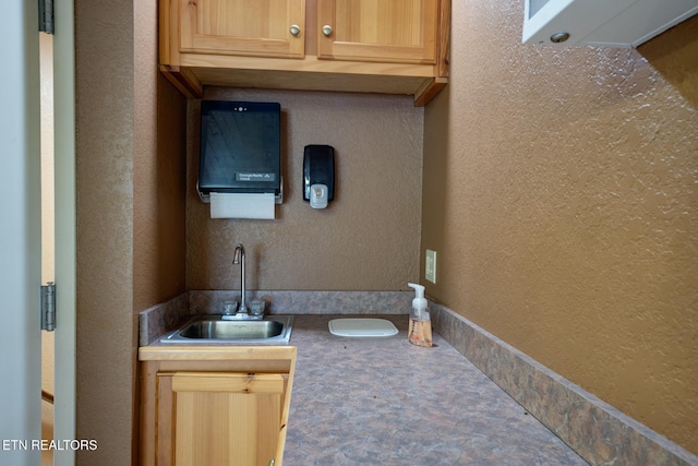 bathroom with a textured wall and a sink