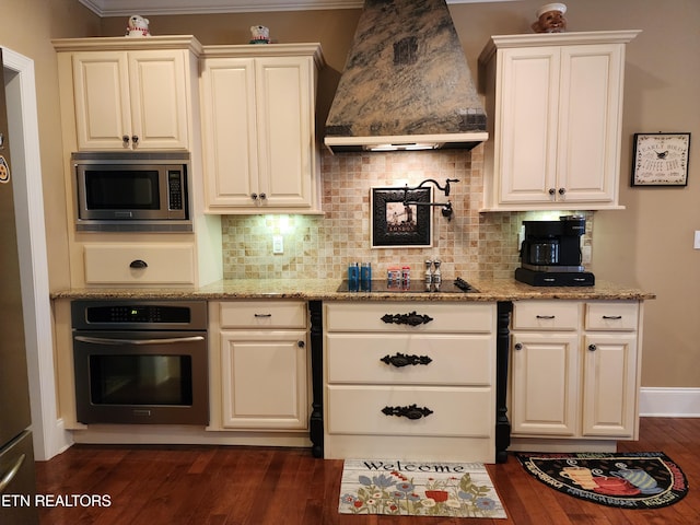 kitchen featuring stainless steel microwave, light stone countertops, premium range hood, and oven