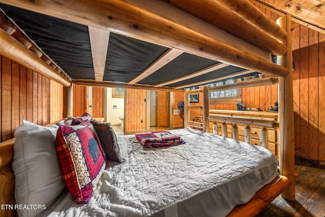 bedroom with wood walls and hardwood / wood-style floors