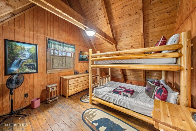 bedroom with wood ceiling, hardwood / wood-style floors, wooden walls, and lofted ceiling with beams