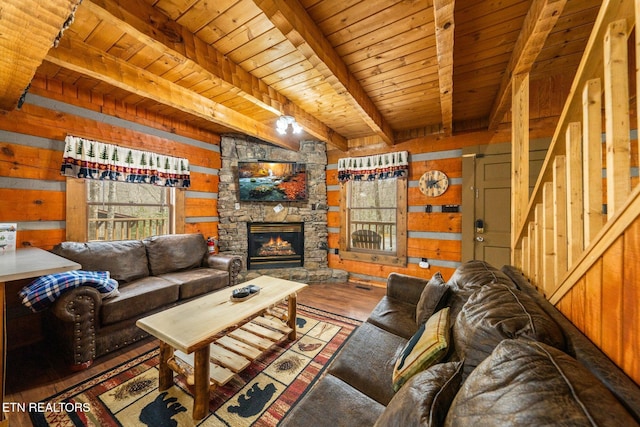 living area with beam ceiling, wood ceiling, a stone fireplace, wooden walls, and wood finished floors