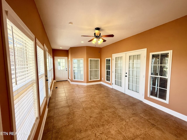 unfurnished sunroom featuring french doors and a ceiling fan