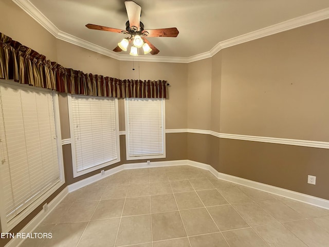 tiled empty room with baseboards, ornamental molding, and ceiling fan