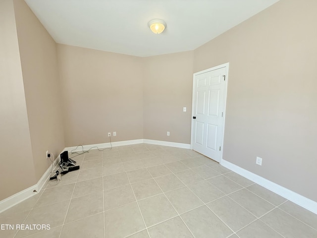 empty room featuring light tile patterned floors and baseboards