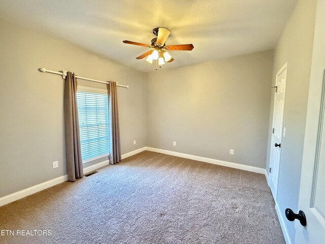 spare room featuring ceiling fan, baseboards, and carpet flooring