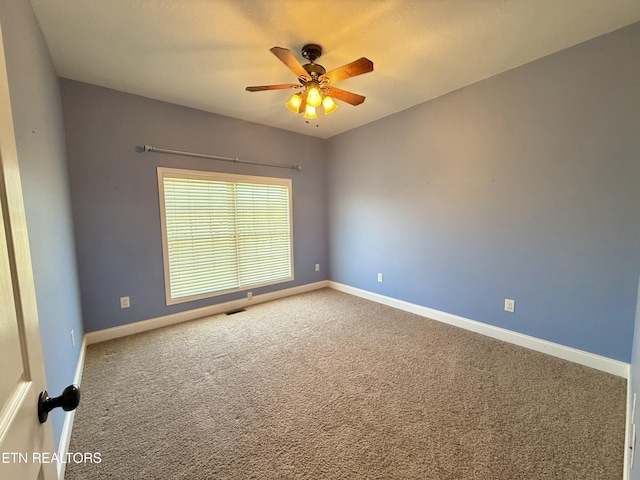 spare room featuring carpet, baseboards, and ceiling fan