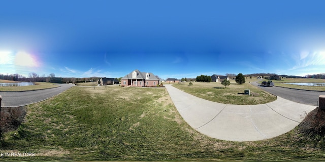 view of community featuring a water view and a yard