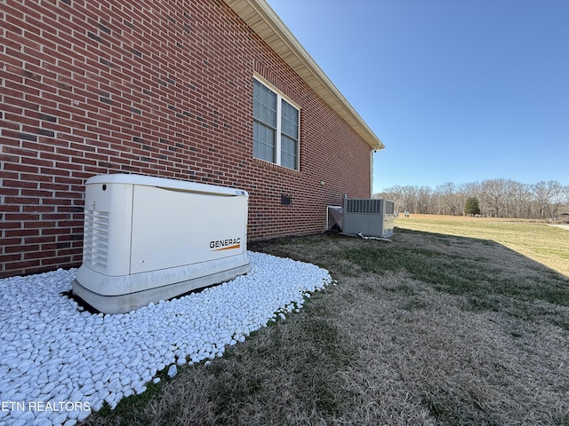 details featuring a power unit, brick siding, and cooling unit