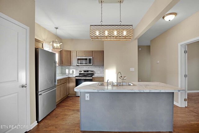 kitchen featuring dark wood finished floors, appliances with stainless steel finishes, backsplash, and a sink