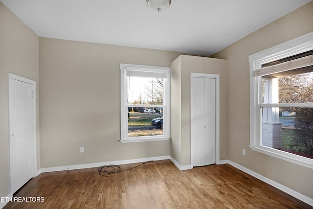 unfurnished bedroom featuring a closet, baseboards, and wood finished floors