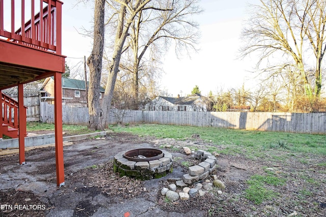 view of yard with a fenced backyard and a fire pit