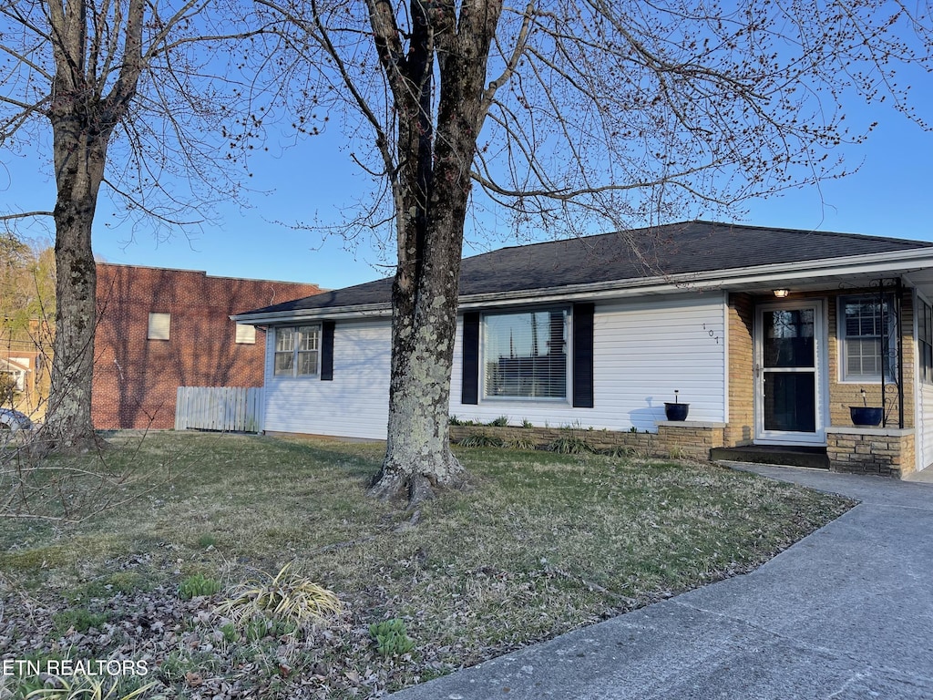 view of front facade featuring a front yard and fence