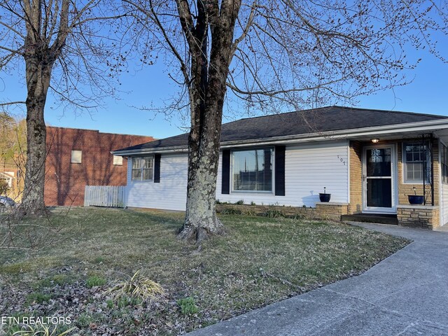 view of front facade featuring a front yard and fence