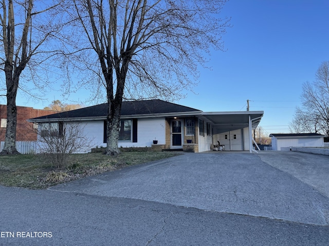 view of front of home with a carport, driveway, and an outdoor structure