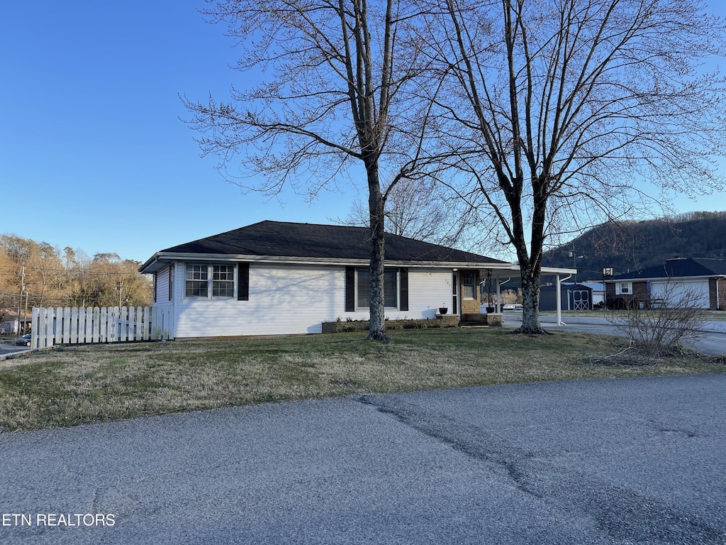 view of front of property featuring fence and a front lawn