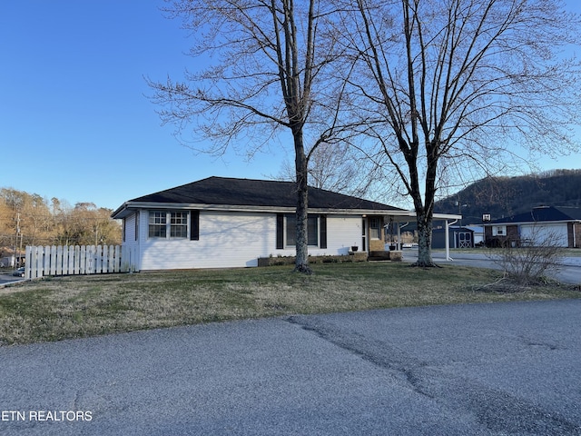 view of front of home featuring a front lawn and fence