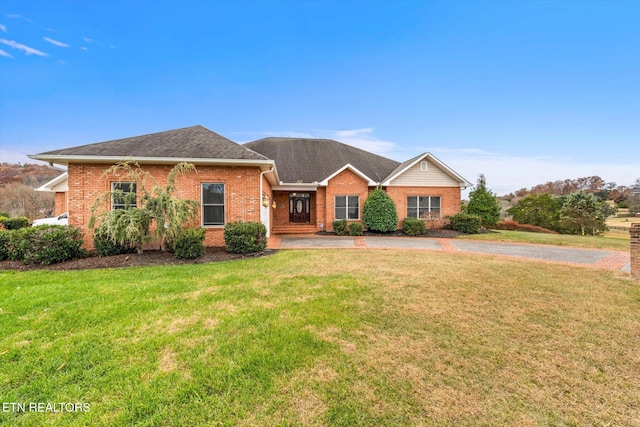 ranch-style home with brick siding, a front yard, and a shingled roof