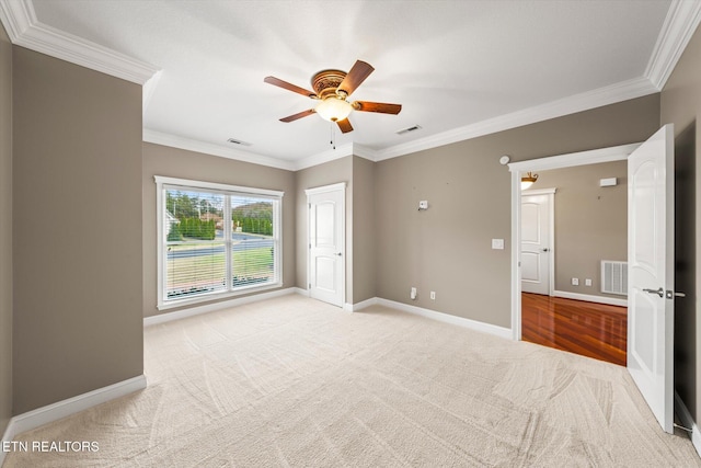 spare room featuring visible vents, crown molding, and baseboards