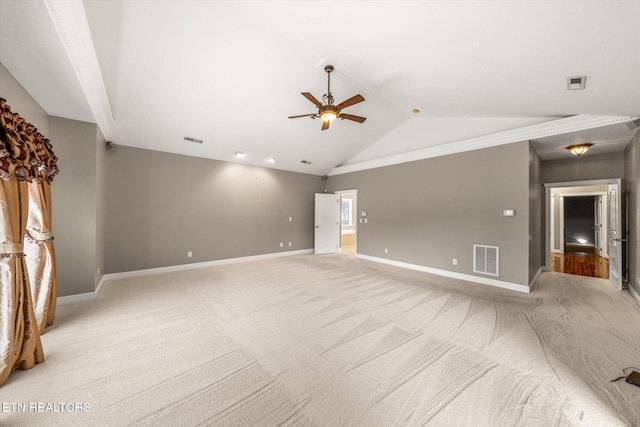 empty room featuring lofted ceiling, visible vents, and baseboards