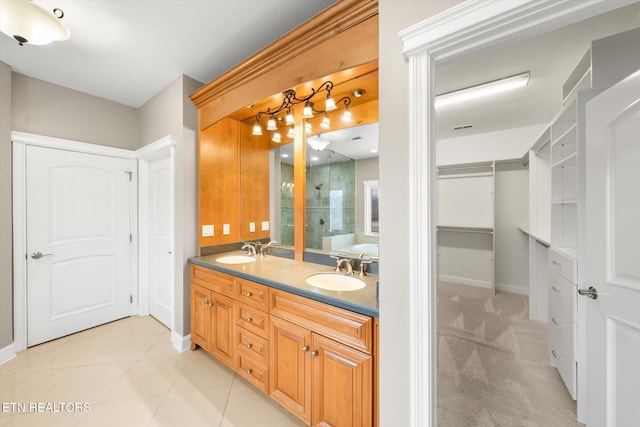 full bathroom featuring double vanity, a sink, baseboards, and tile patterned floors