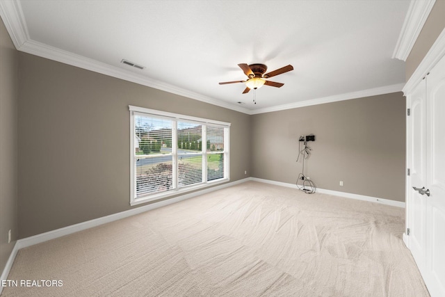 spare room featuring light carpet, baseboards, visible vents, and ornamental molding