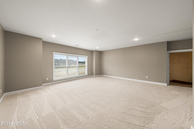 unfurnished room featuring recessed lighting, light carpet, and baseboards