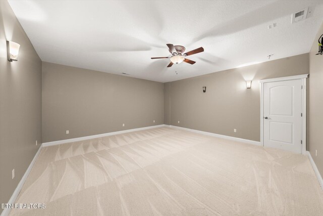 empty room with ceiling fan, baseboards, visible vents, and light colored carpet