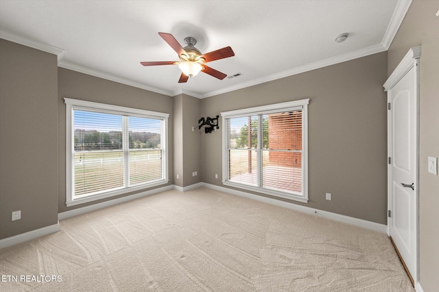 unfurnished room featuring light carpet, plenty of natural light, and crown molding